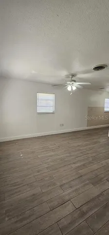 a view of a kitchen with wooden floor and electronic appliances