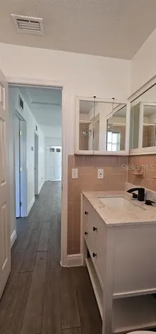 an empty room with wooden floor fan and window