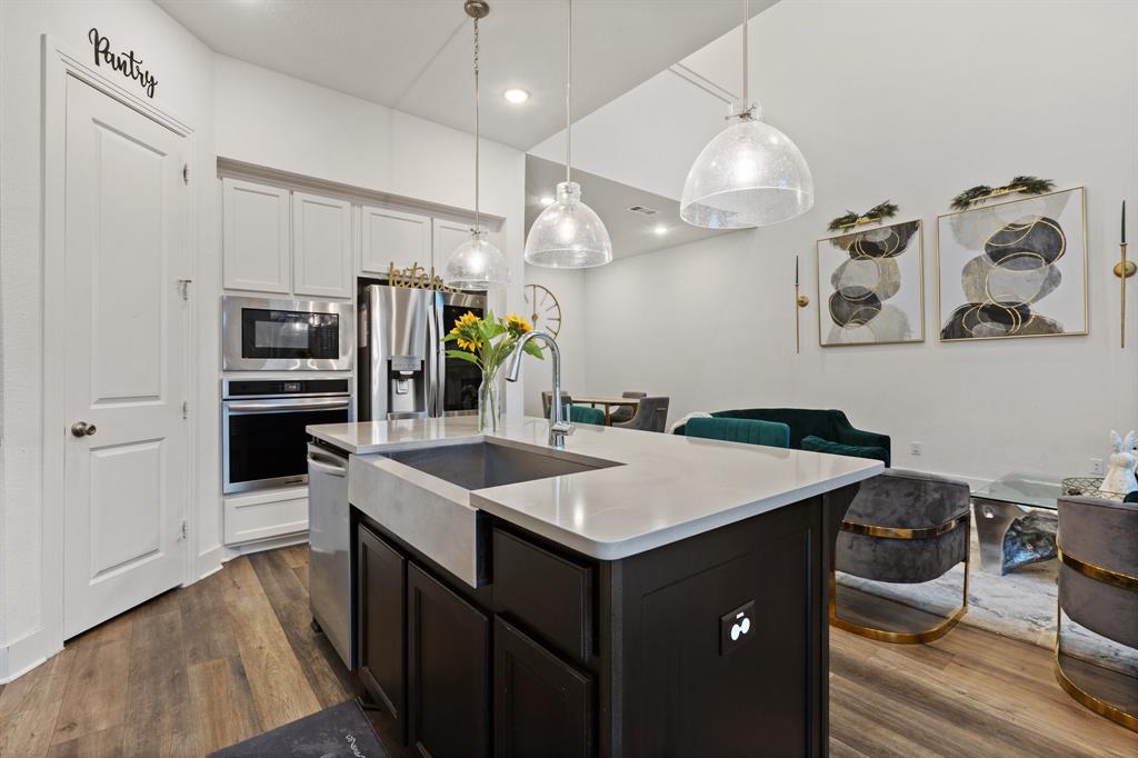 1124 Queensdown Way Forney, TX 75126 - Photo 11 of 34 a kitchen with a sink a stove and chairs
