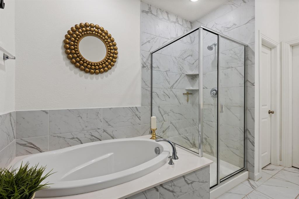 1124 Queensdown Way Forney, TX 75126 - Photo 19 of 34 a bathroom with a shower a mirror and a bathtub