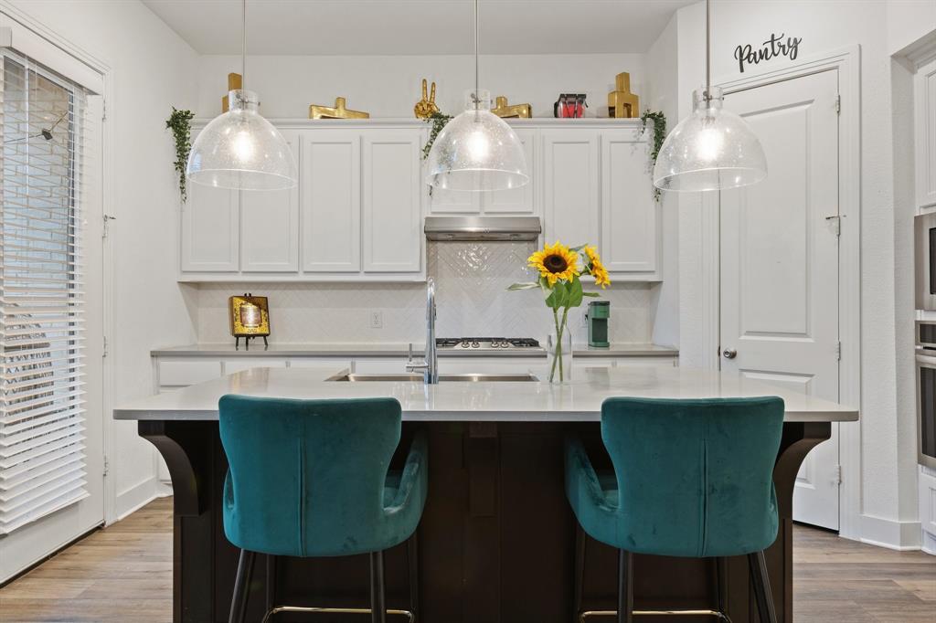 1124 Queensdown Way Forney, TX 75126 - Photo 4 of 34 a kitchen with stainless steel appliances granite countertop a sink cabinets and wooden floor