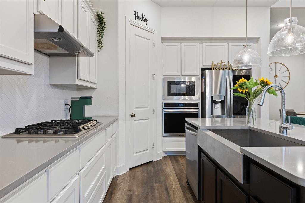 1124 Queensdown Way Forney, TX 75126 - Photo 10 of 34 a kitchen with stainless steel appliances a sink a stove and cabinets
