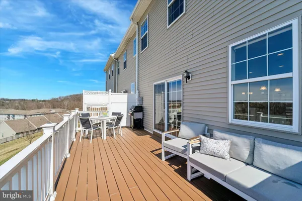 a view of a roof deck with table and chairs with wooden floor and fence