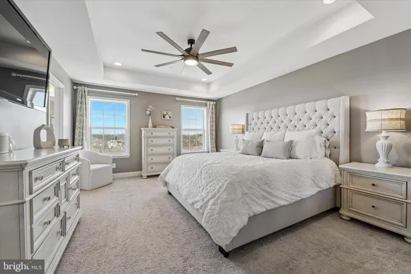a spacious bedroom with a bed and ceiling fan