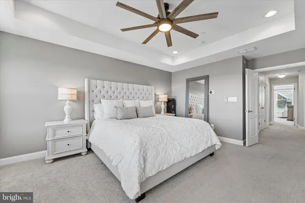 a spacious bedroom with a bed and a ceiling fan