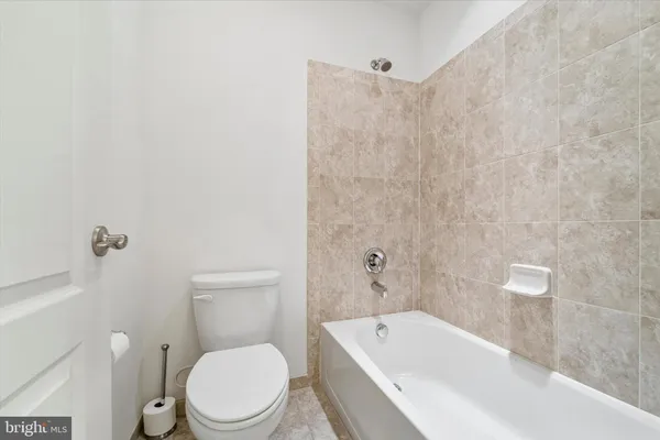 a white toilet sitting next to a bath tub