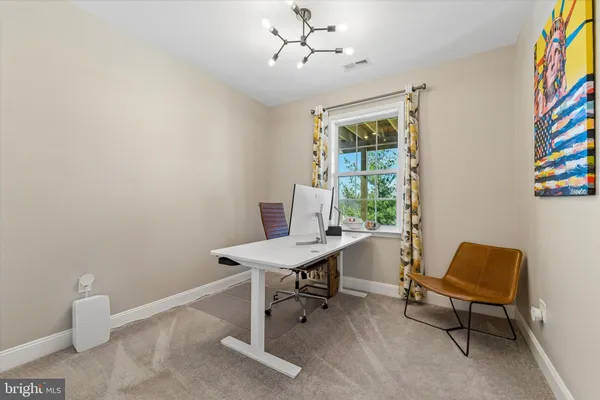 a view of a workspace with furniture and a window