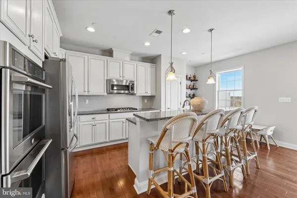 a large white kitchen with lots of counter top space appliances and cabinets