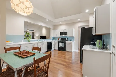 a large kitchen with stainless steel appliances kitchen island granite countertop a refrigerator a sink a stove a dining table and chairs