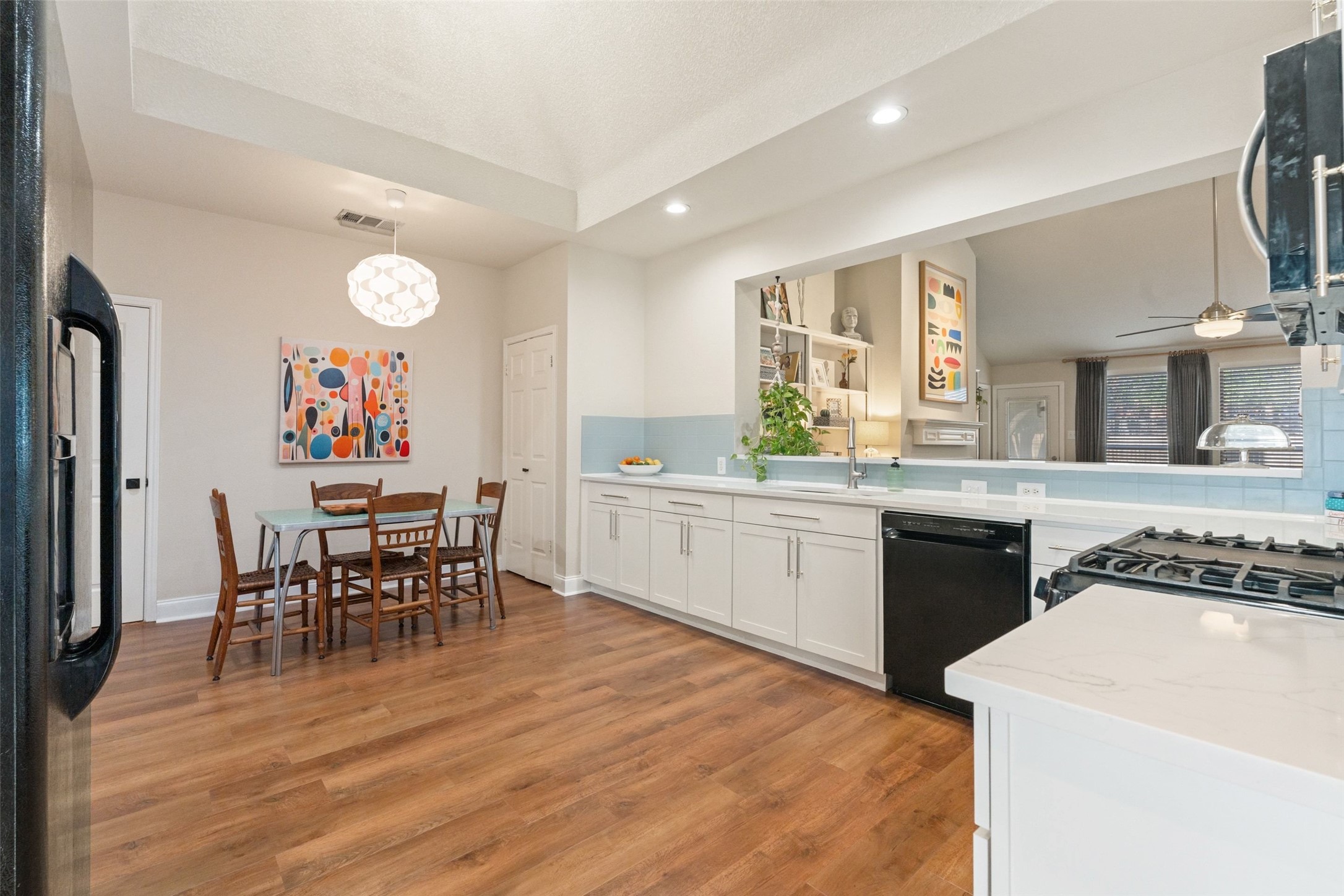 11016 Amaranth Lane Austin, TX 78754 - Photo 13 of 36 a kitchen with stainless steel appliances granite countertop a stove top oven a sink dishwasher a dining table and chairs with wooden floor