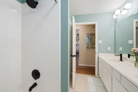a bathroom with a sink a large mirror and a shower