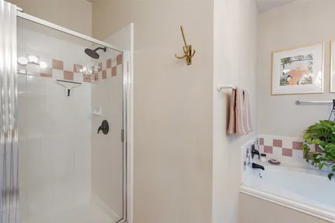 a spacious bathroom with a double vanity sink a mirror and a shower