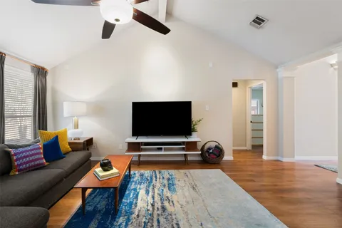 a living room with furniture kitchen view and a flat screen tv