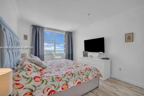 a bedroom with a bed and a flat screen tv