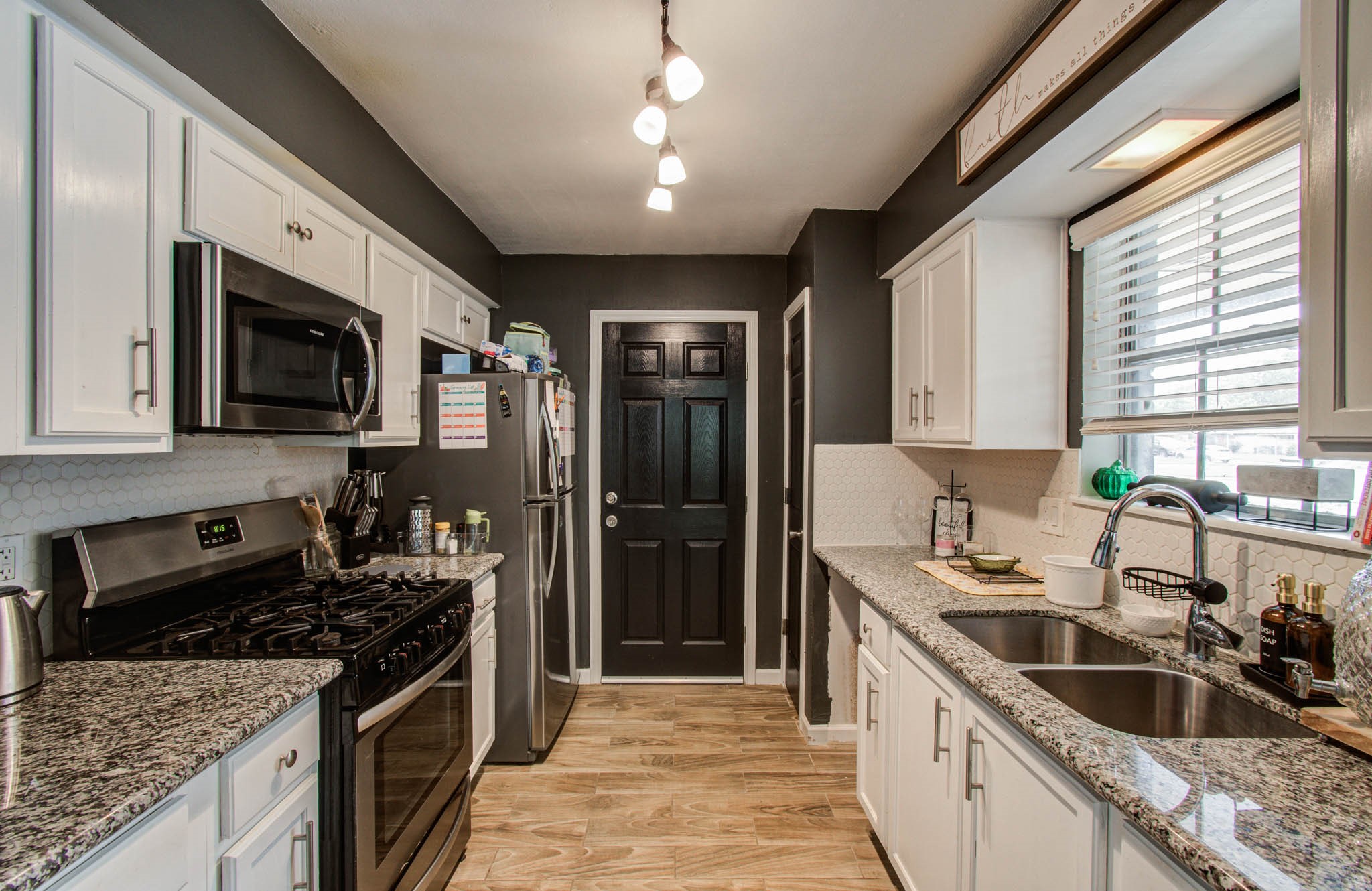 1327 Fallbrook Drive Houston, TX 77038 - Photo 12 of 34 a kitchen with stainless steel appliances granite countertop sink stove microwave refrigerator and cabinets