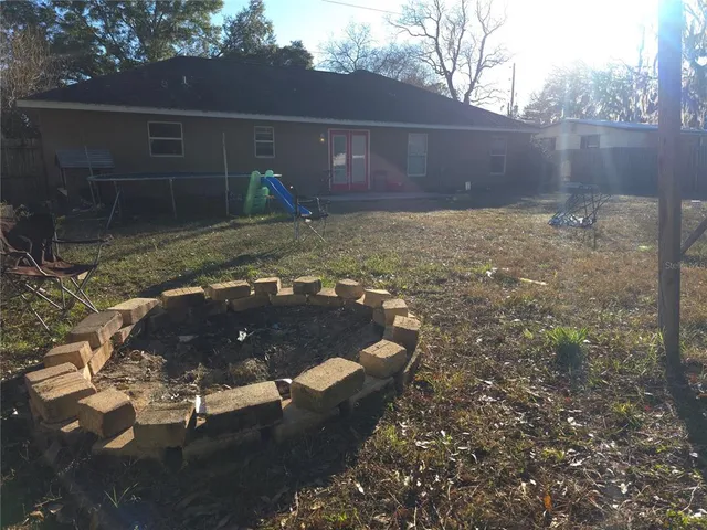 a view of a house with backyard and sitting area
