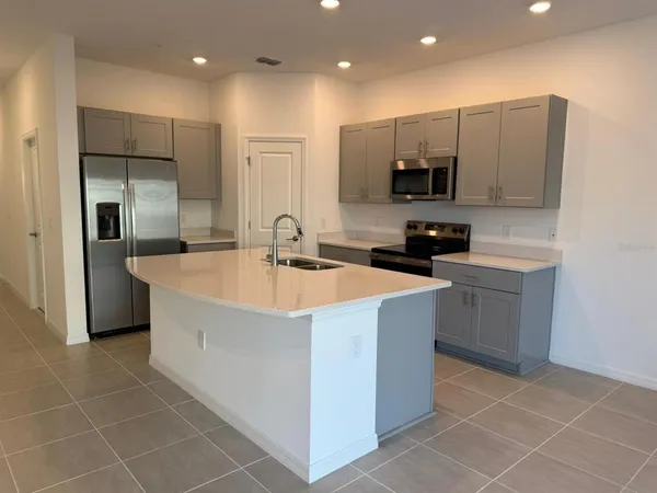 a kitchen with stainless steel appliances a sink a stove a refrigerator and cabinets