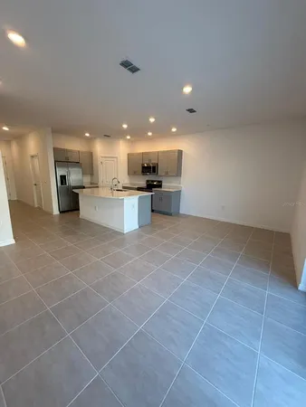 a view of a kitchen with kitchen island granite countertop a large window and a counter top space