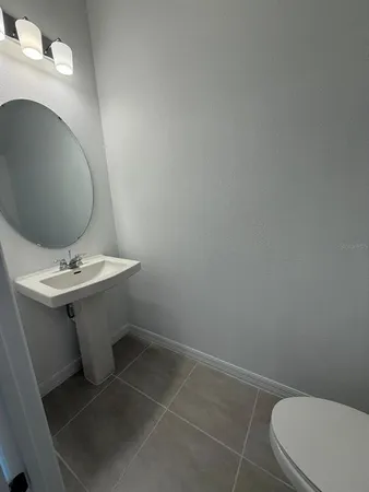 a bathroom with a sink toilet and a mirror