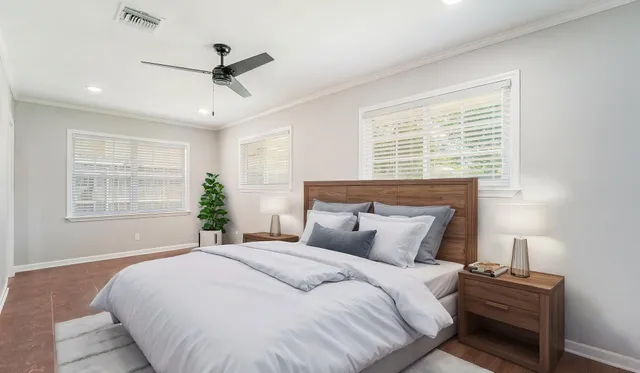 a bedroom with a large bed and a ceiling fan