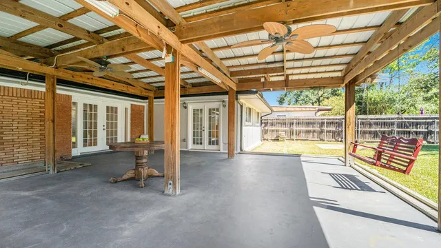 a view of a patio with a table and chairs next to a yard