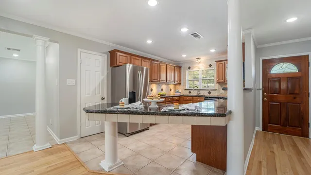 a kitchen with stainless steel appliances granite countertop a sink and a refrigerator