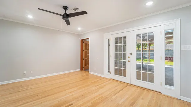 a view of an empty room with a window and wooden floor