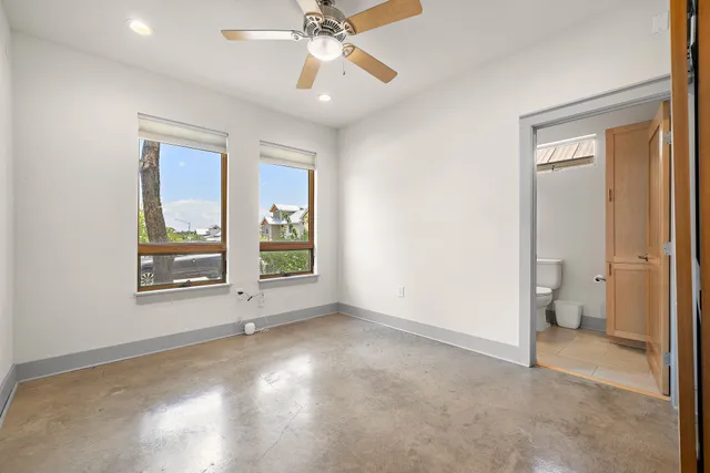 a bathroom with a granite countertop toilet sink and mirror