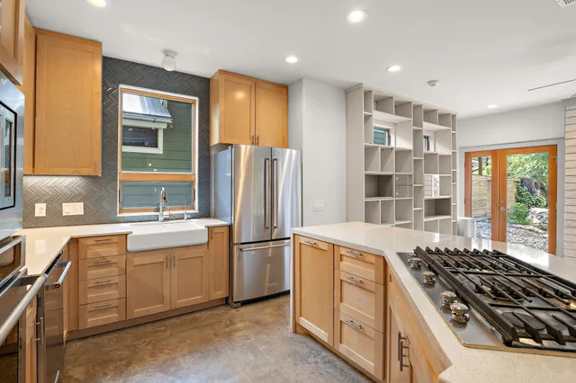 a large kitchen with stainless steel appliances granite countertop a stove and a refrigerator
