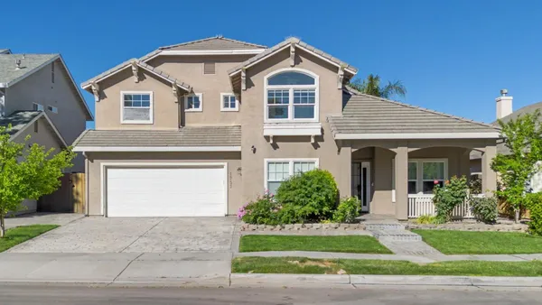 a front view of a house with a garden and plants