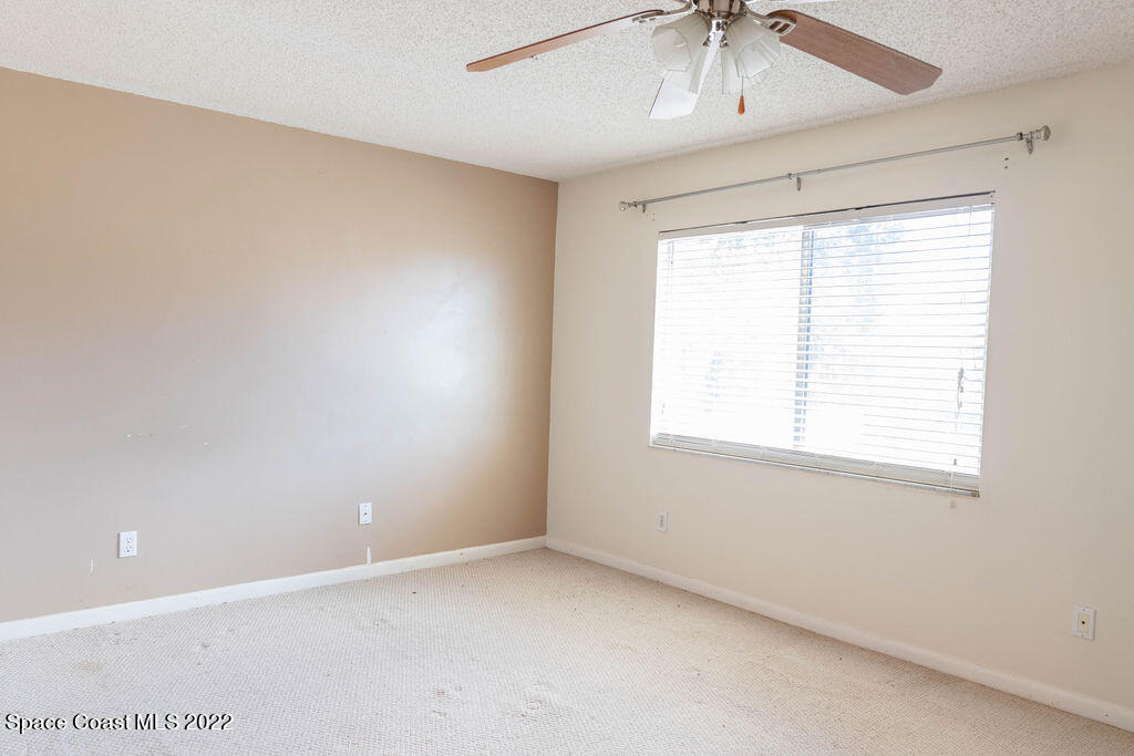 1880 Murrell Road, Unit 18 Rockledge, FL 32955 - Photo 19 of 26 an empty room with a window and a ceiling fan