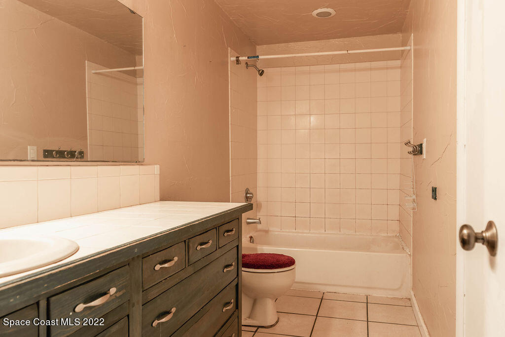 1880 Murrell Road, Unit 18 Rockledge, FL 32955 - Photo 23 of 26 a bathroom with a granite countertop sink a toilet and shower