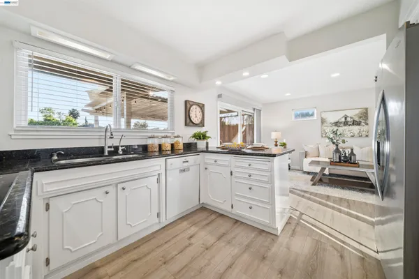 a kitchen with white cabinets and appliances