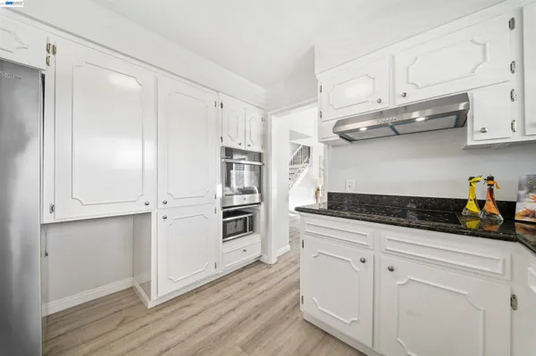 a living room with furniture a table and kitchen view