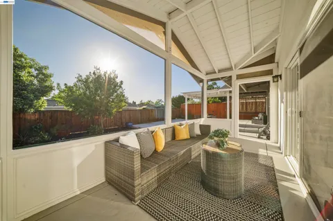 a view of a patio with table and chairs with wooden floor and fence