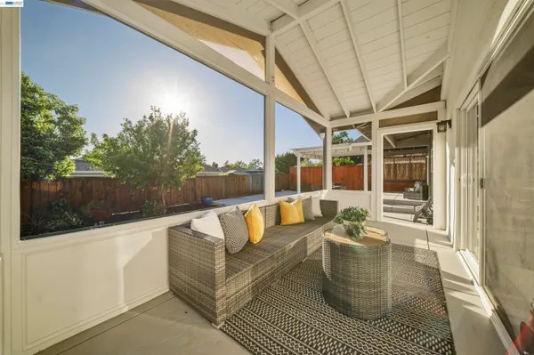 a view of a patio with table and chairs with wooden floor and fence