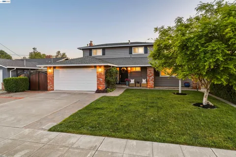 a view of a backyard with couches under an umbrella