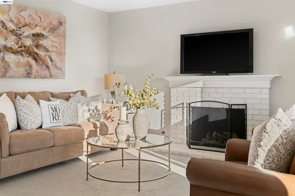 a living room with furniture a fireplace and a flat screen tv