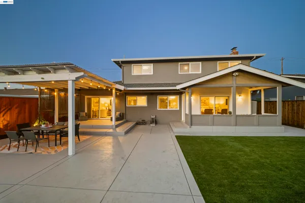 a view of a patio with a table and chairs and a barbeque