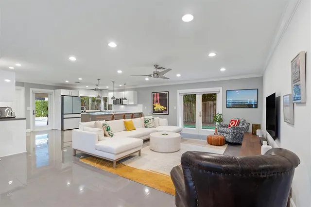 a living room with lots of furniture and view of kitchen