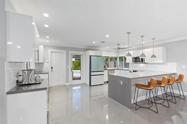 a kitchen with stainless steel appliances kitchen island granite countertop a table and chairs in it