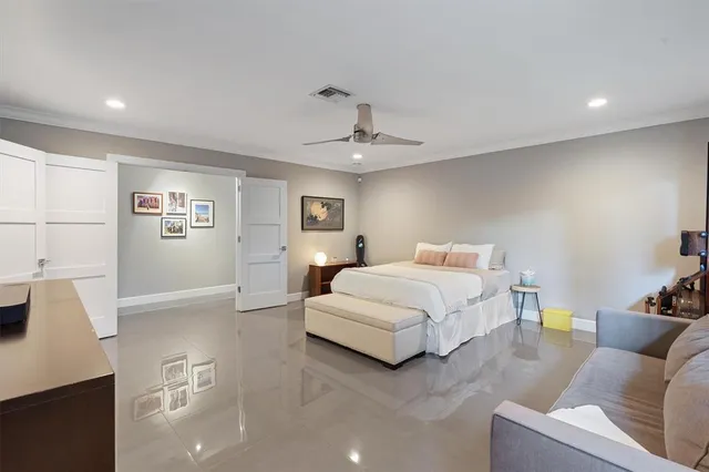 a spacious bedroom with a bed a couch and a large window