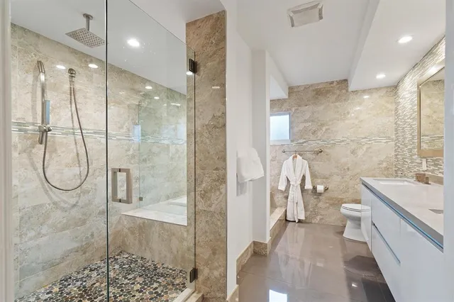 a bathroom with a double vanity sink toilet and a mirror