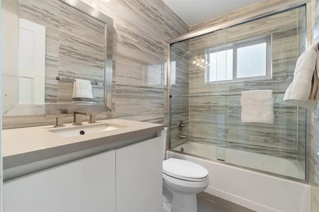 a bedroom with a bed a table and a large window