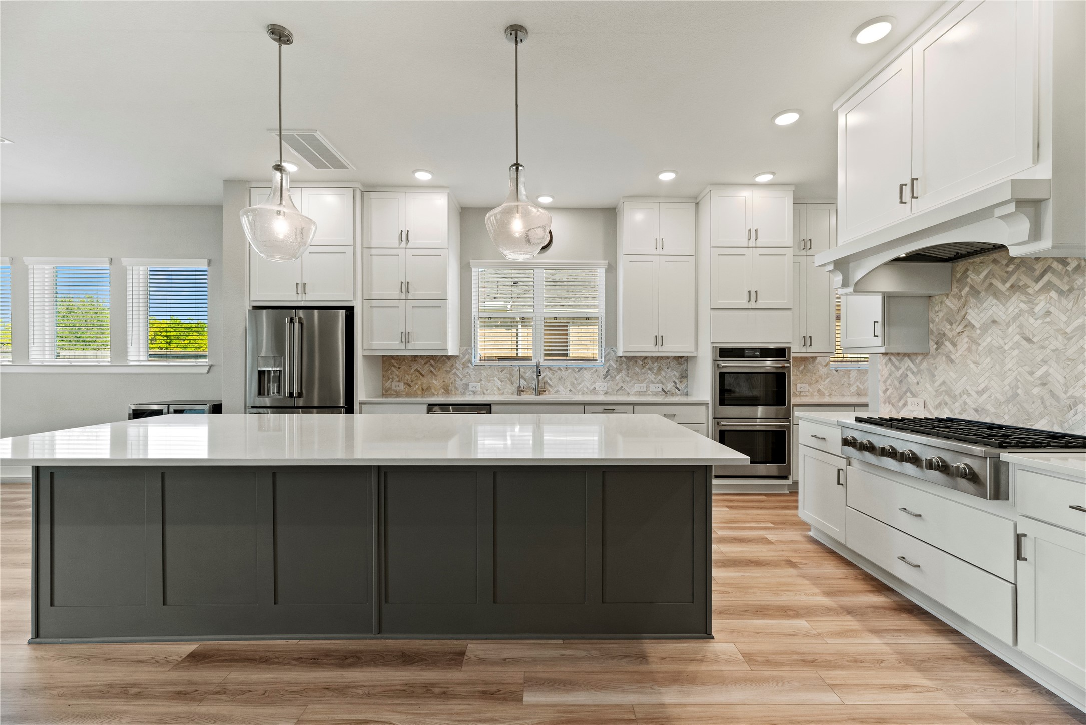 3111 Swift Way Katy, TX 77493 - Photo 25 of 50 a large kitchen with granite countertop a stove a sink a center island and wooden floor