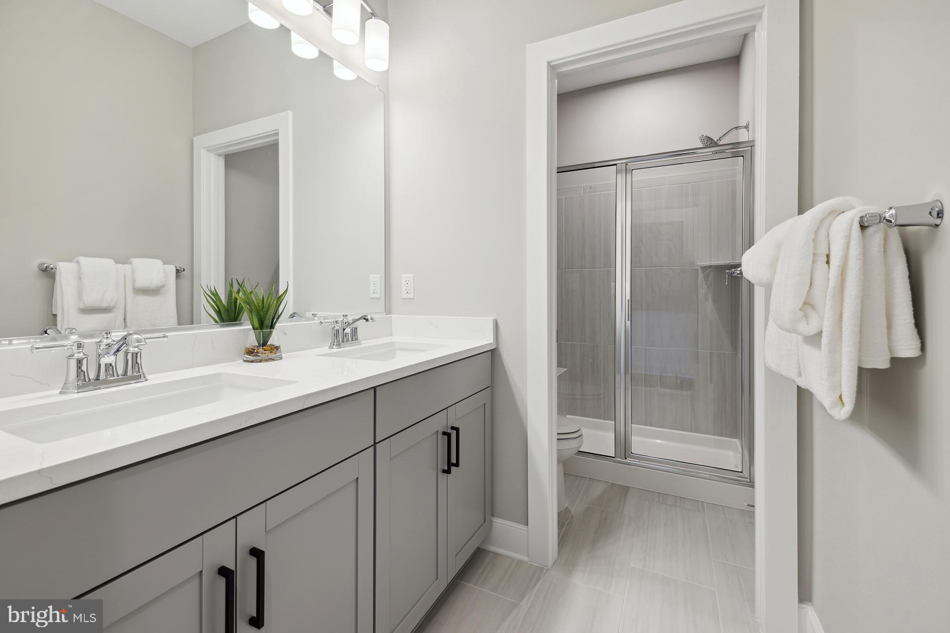 14406 Dowitcher Way, Unit 1 Boyds, MD 20841 - Photo 23 of 50 a bathroom with a double vanity sink mirror and shower