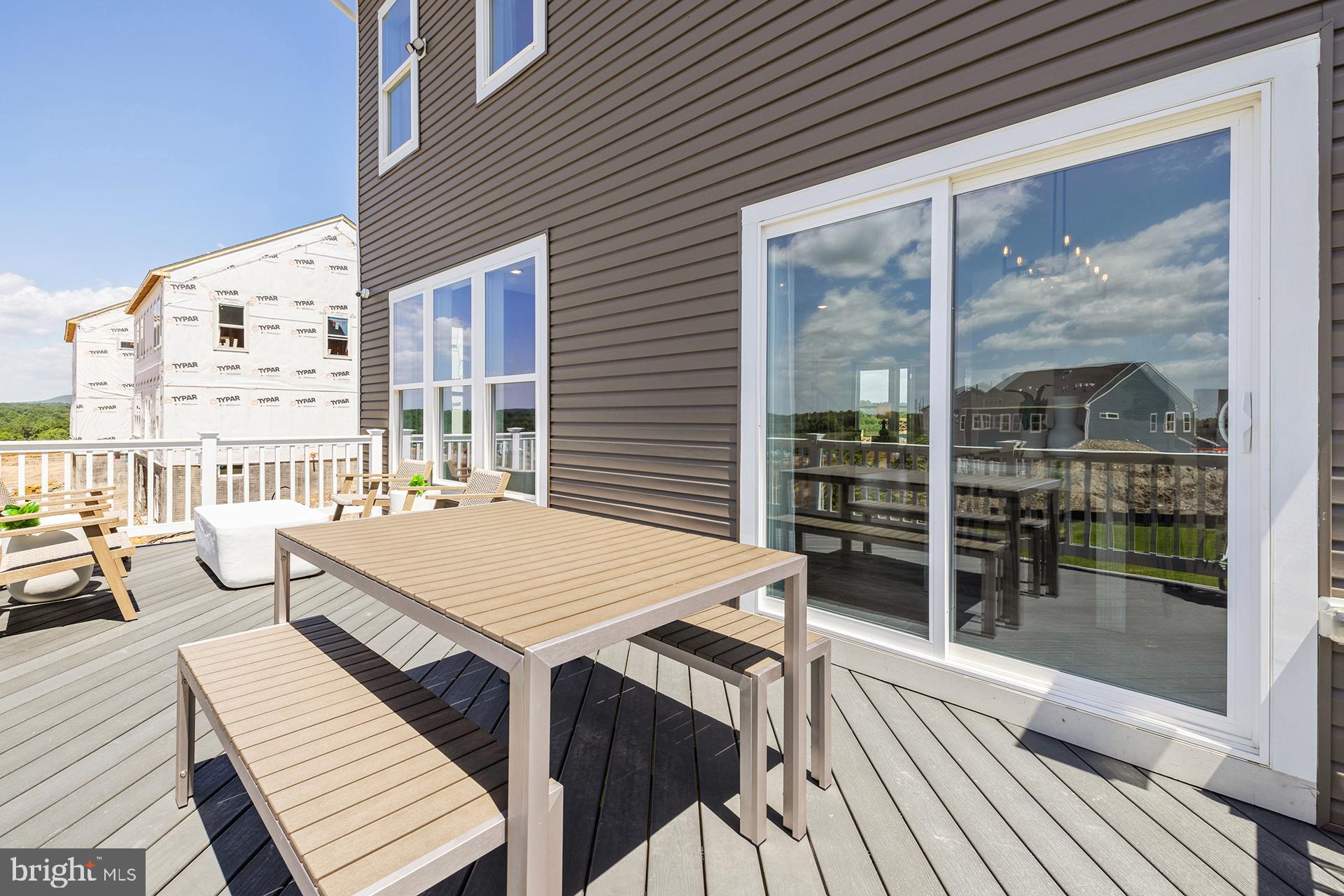 14406 Dowitcher Way, Unit 1 Boyds, MD 20841 - Photo 30 of 50 a view of a patio with table and chairs with wooden floor and floor to ceiling window