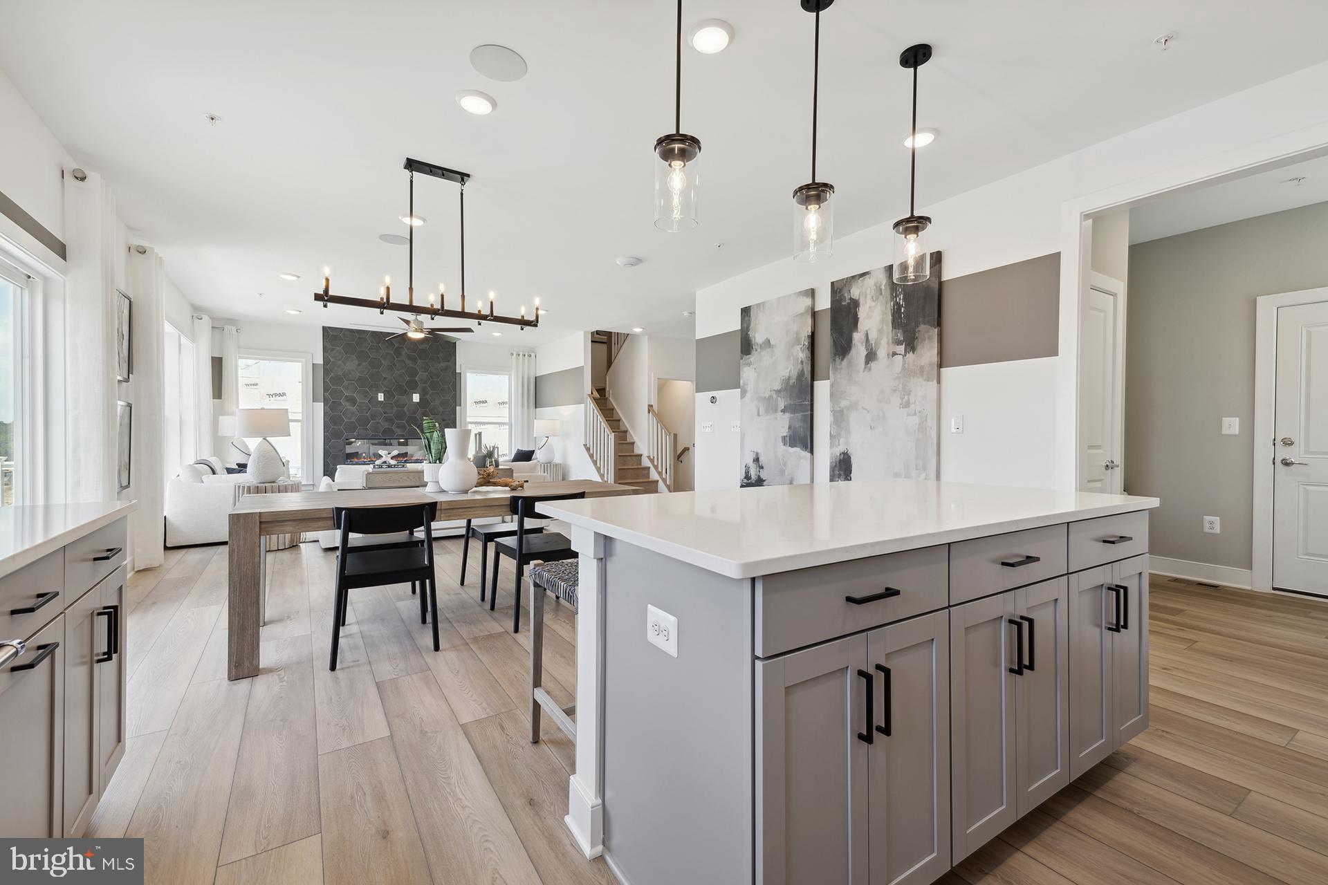 14406 Dowitcher Way, Unit 1 Boyds, MD 20841 - Photo 9 of 50 a kitchen with stainless steel appliances kitchen island a large island in the center and wooden floors