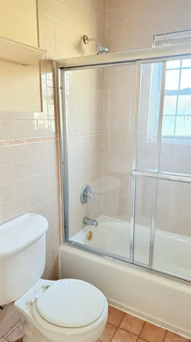 a white toilet and tub next to a window