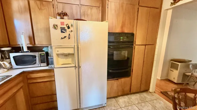 a white refrigerator freezer and a stove sitting inside of a kitchen